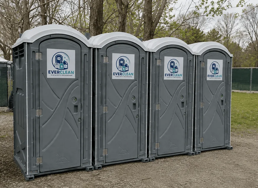 Bank of four grey Everclean Porta Potty Philadelphia portable toilets lined up at a temporary site