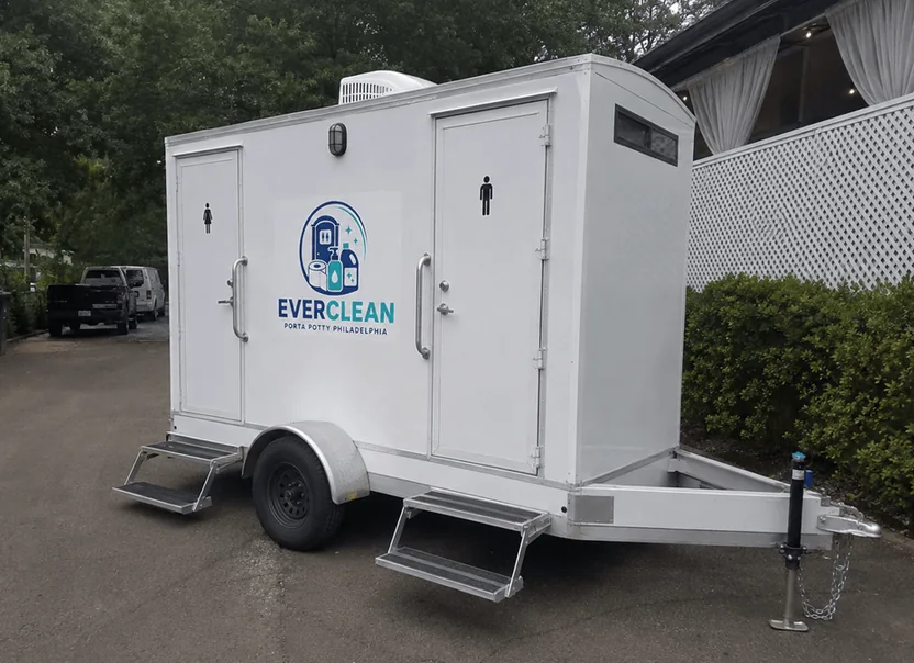 Two door restroom trailer parked at an outdoor venue